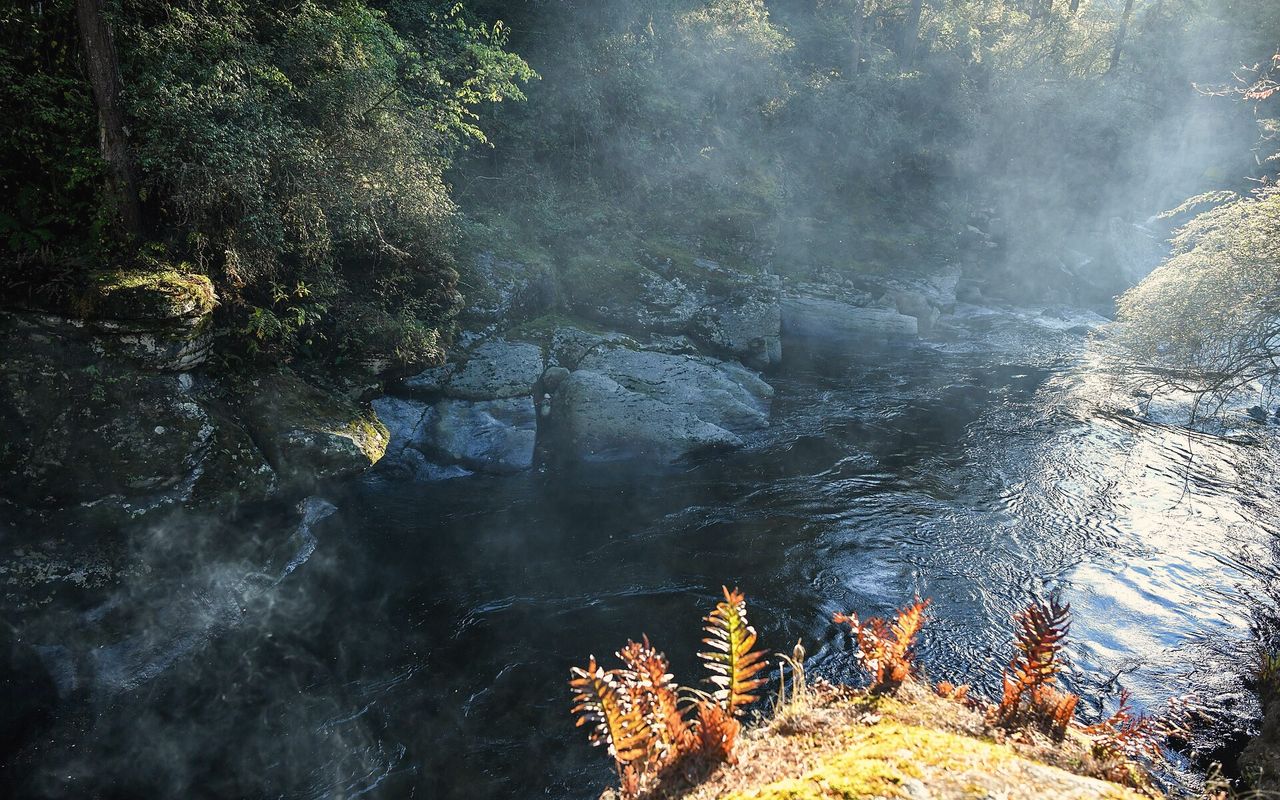 Mebar Tsho, the Burning Lake, a dark pool in a rocky gorge hung with prayer flags.