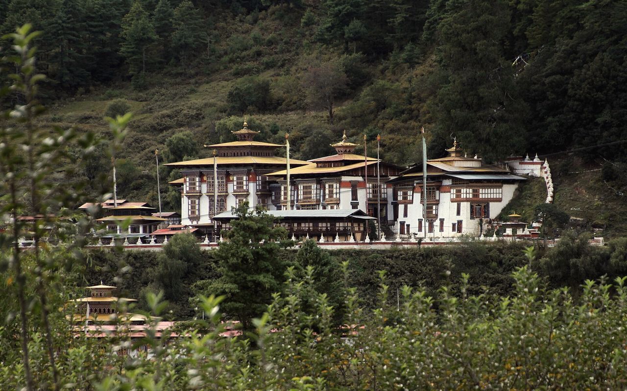 The temples of Kurjey Lhakhang against the hillside.